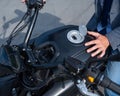 A man opened the charging socket on an electric motorcycle.