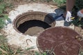 The man opened the manhole cover of the well. Checking and installing water metering Royalty Free Stock Photo