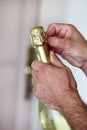 Man is opening a bottle of champagne. Waiter opens a bottle of wine. Man hands open bottle of champagne alcohol and wine drink. Royalty Free Stock Photo