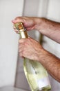 Man is opening a bottle of champagne. Waiter opens a bottle of wine. Man hands open bottle of champagne alcohol and wine drink. Royalty Free Stock Photo