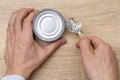 Man opening a can with a can opener