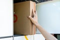 Man opening a door of post office box on the city street and receive a parcel. Man carrying box from post office delivery. Royalty Free Stock Photo