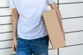 Man opening a door of post office box on the city street and receive a parcel. Man carrying box from post office delivery. Royalty Free Stock Photo