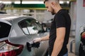 Man opening fuel tank cover on his car for refueling at gas station. Petrol prices concept Royalty Free Stock Photo