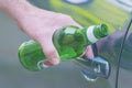 Man opening his car while holding a bottle of beer Royalty Free Stock Photo