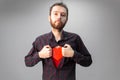 Man opening his shirt with a red heart on his chest. Saint Valentine`s day concept