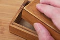 A man opening a small old empty wooden box with his hand Royalty Free Stock Photo