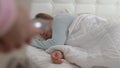 Man opens bedroom door to look at sleeping woman in morning