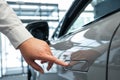 A man opens a car door with a fingerprint. Integrated handle.