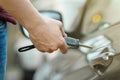 A man opens a rent car sharing door with a key, close-up hand Royalty Free Stock Photo