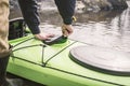 The man opens a sealed hatch cover for things in the kayak that