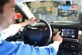 man operates navigation device in car in a car dealership and tests it Royalty Free Stock Photo