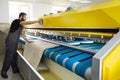 Man operating carpet automatic washing machine in professional laundry service Royalty Free Stock Photo