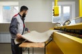 Man operating carpet automatic washing machine in professional laundry service Royalty Free Stock Photo