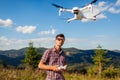 Man operating copter controller in mountains. Drone remote control. Aerial footage shooting of summer Carpathins Royalty Free Stock Photo