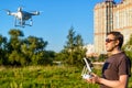 Man operating drone quad copter in city park