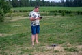 A man operating the drone by remote control on the meadow near forest Royalty Free Stock Photo