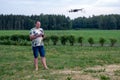 A man operating the drone by remote control on the meadow near forest Royalty Free Stock Photo