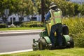A man operating a large standup lawnmower