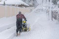 Man operating snow blower to remove snow on driveway. A man cleans the road from the snow. Snowy road. snowy winter Royalty Free Stock Photo