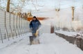 Man operating snow blower to remove snow on driveway Royalty Free Stock Photo