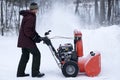 Man Operating Snow Thrower in Driveway