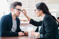 Man in optician shop getting advice from saleswoman