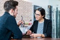 Man in optician shop getting advice from saleswoman