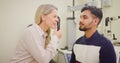 Man at the optometrist doing an eye exam to check his eyesight. Indian male at a checkup with an opthalmologist to