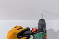 Man with orange gloves using an electric drill on a wall Royalty Free Stock Photo