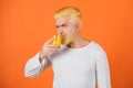 Man with orange hair drinking fresh orange juice Concept of healthy food and lifestyle. Young man with glass of orange