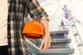 Man with orange hard hat at construction site with unfinished building, closeup. Space for text Royalty Free Stock Photo