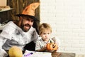 Man in orange hat and kid with happy, interested faces