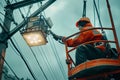 A man in an orange jacket is on a lift, installing a street light on a pole Royalty Free Stock Photo