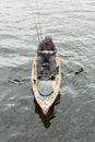 The man in the orange kayak to catch fish. He wears a black hood.