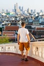 Man standing at the stairs of Golden Mount temple overlooking the city of Bangkok, Thailand