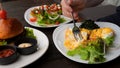 Man ordered three vegetarian dishes poached eggs, salad, healthy burger, avocado toast. Man eating vegetarian poached