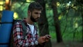 Man orienteering in forest, using navigational compass, survival classes