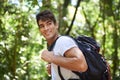 Man, outdoor and backpack for hiking in rainforest with smile for adventure, holiday and thinking in summer. Person Royalty Free Stock Photo