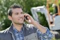 Man outdoors on telephone digger in background Royalty Free Stock Photo