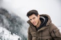 Man in outerwear sitting while looking at camera