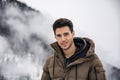 Man in outerwear sitting while looking at camera