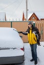 A man outside cleaning off the car after snow flurry Royalty Free Stock Photo