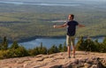 A Man with Outstretched Arms Stands on Cadillac Mountain