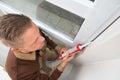 Man In Overall Applying Silicone Sealant