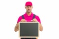 Man in overall with empty board. place for copy space. announcement concept. male construction worker with presentation Royalty Free Stock Photo
