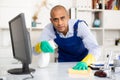 Man in an overalls cleans the table Royalty Free Stock Photo