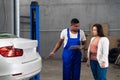 Repairer talking to a woman about a car Royalty Free Stock Photo