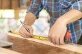 man owner a small furniture business is preparing wood for production. carpenter male is adjust wood to the desired size.