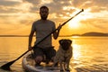 Man paddle boarding at lake during sunset together with pug dog. Concept of active tourism with pets